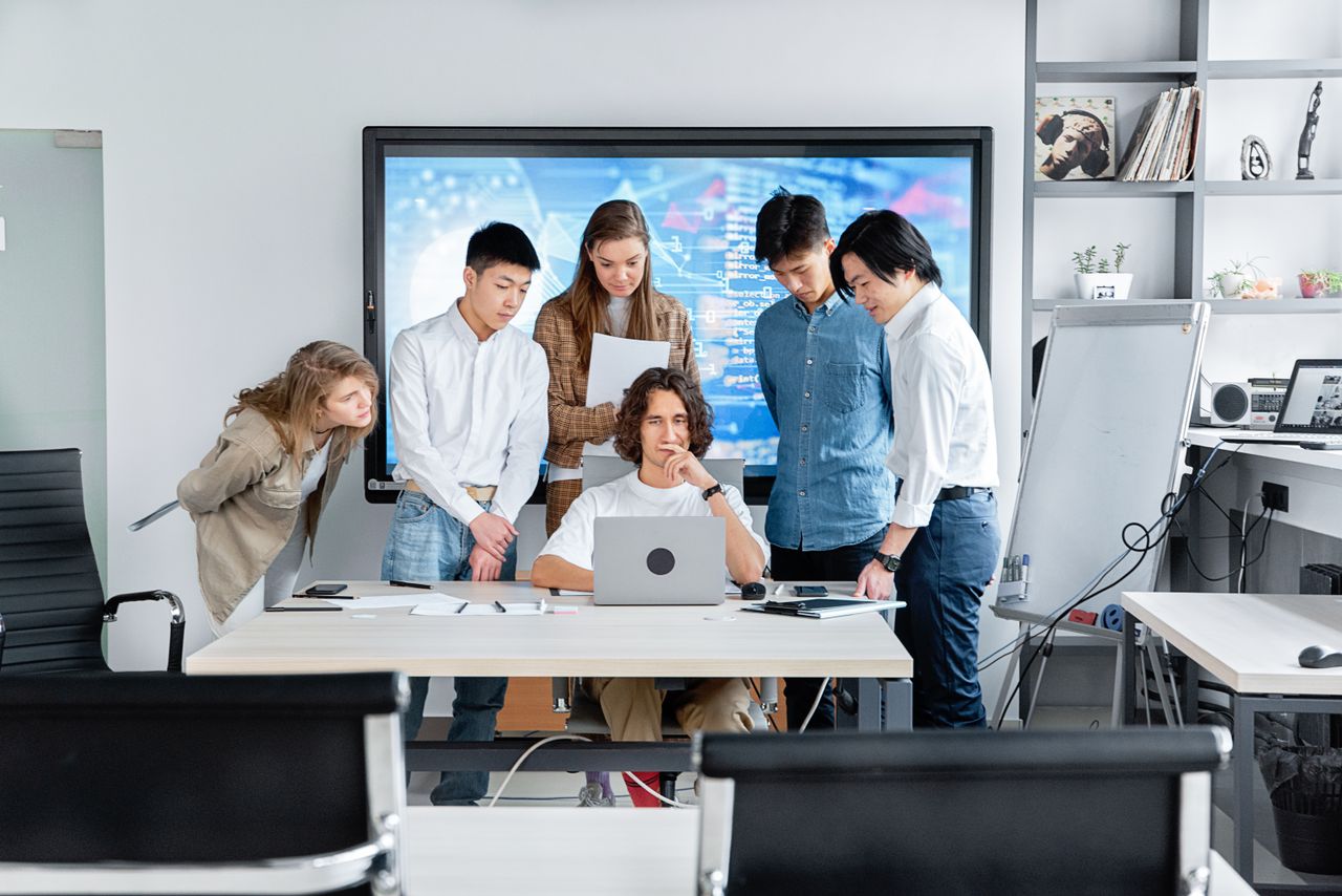 Services Diverse team collaborating on a software project in a contemporary office setting.